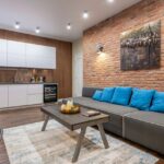 Efektowna aranżacja salonu z aneksem kuchennym, to m.in. styl industrialny.